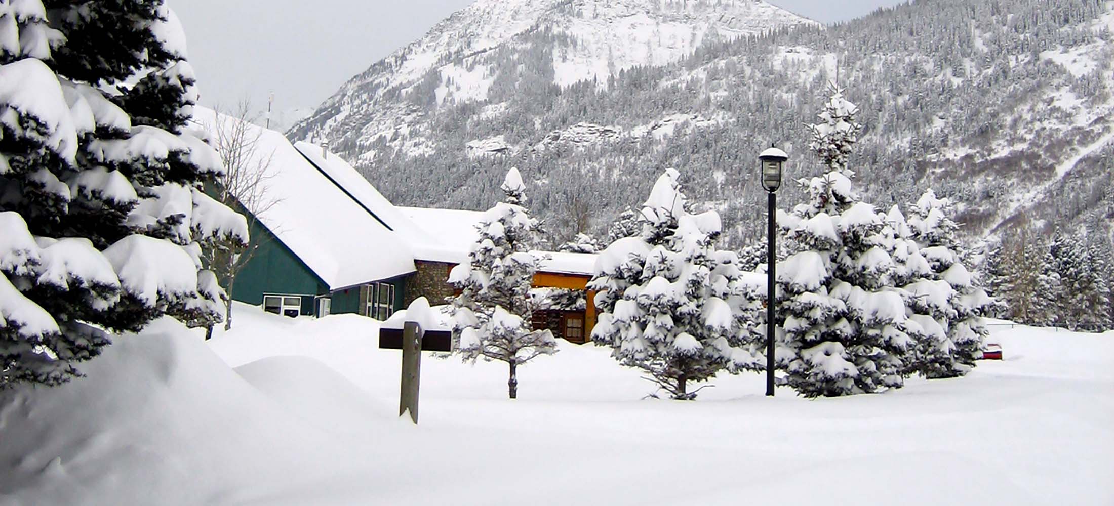 The Waterton Lakes Lodge main building blanketed under a thick layer of snow in the heart of winter.