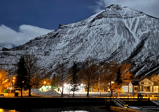 A photo from inside a tent looking out onto the campfire and forest on a summer afternoon.